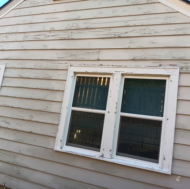 Weathered siding around a white-trimmed window