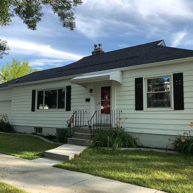 Single-story white house with dark shutters