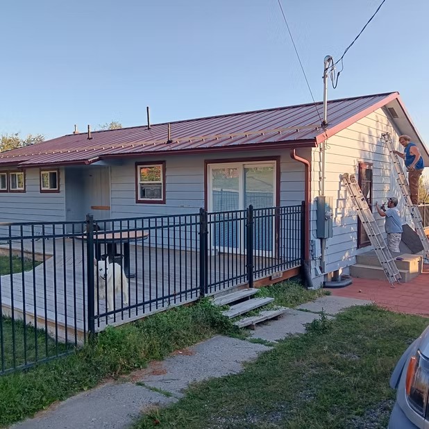 Exterior siding preparation beside a fence