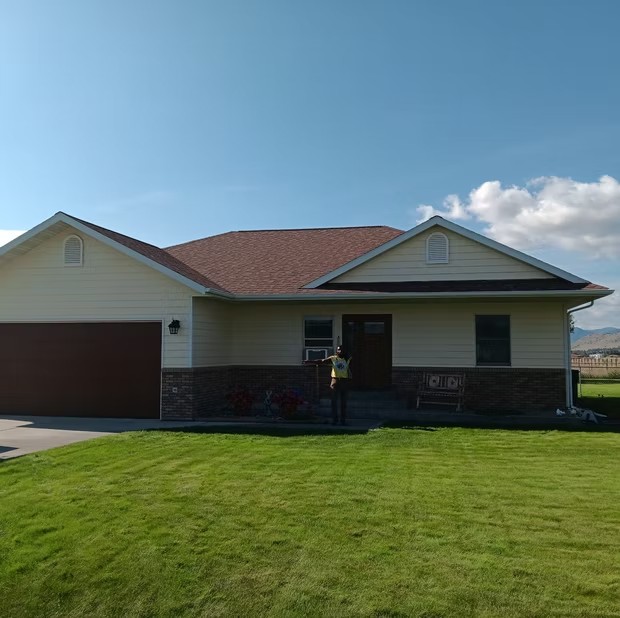 House with a covered entry and lawn